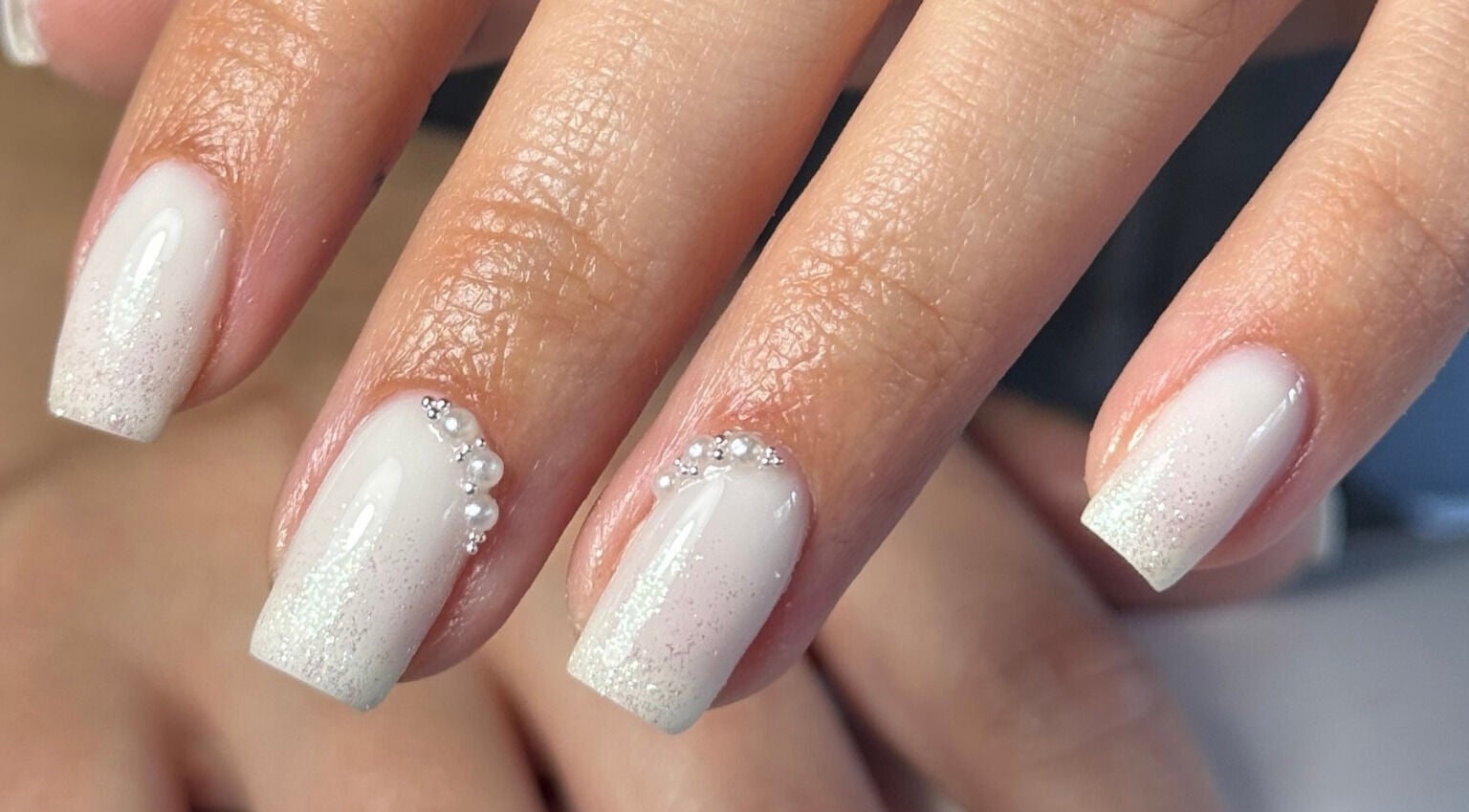 Elegant pearl nail art at Ameliaelizabethnails in Stoke-on-Trent, England, GB with shimmering accents.