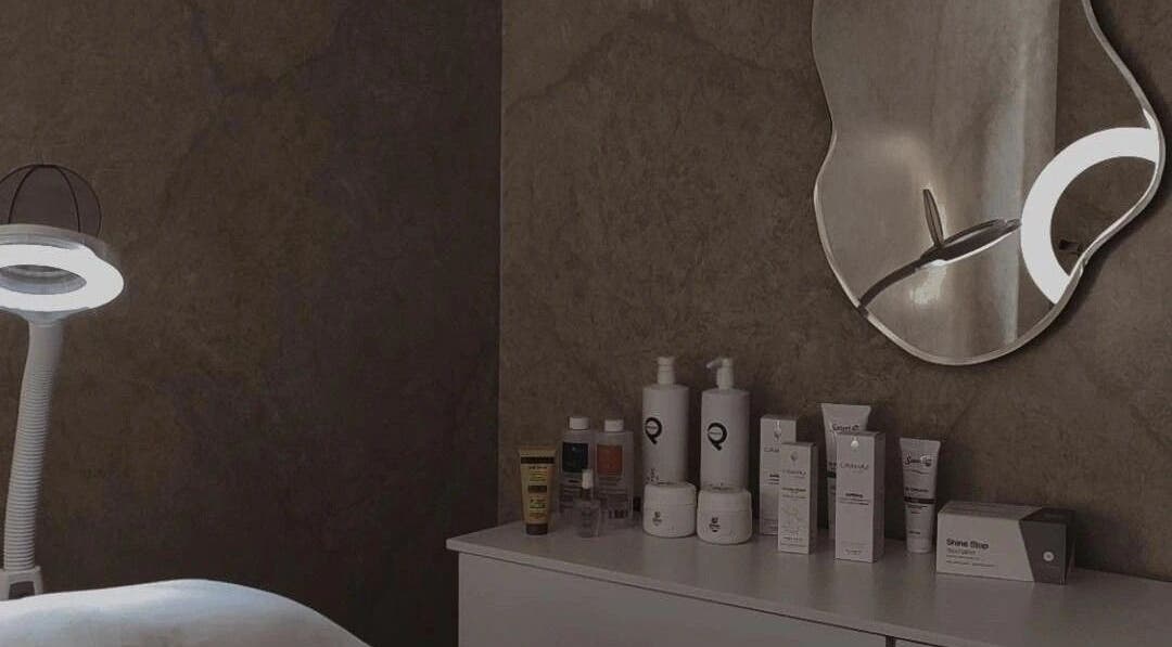 Sala de tratamientos en Amarna Aesthetics en Marbella, Andalucía, ES, con espejo y productos de belleza.