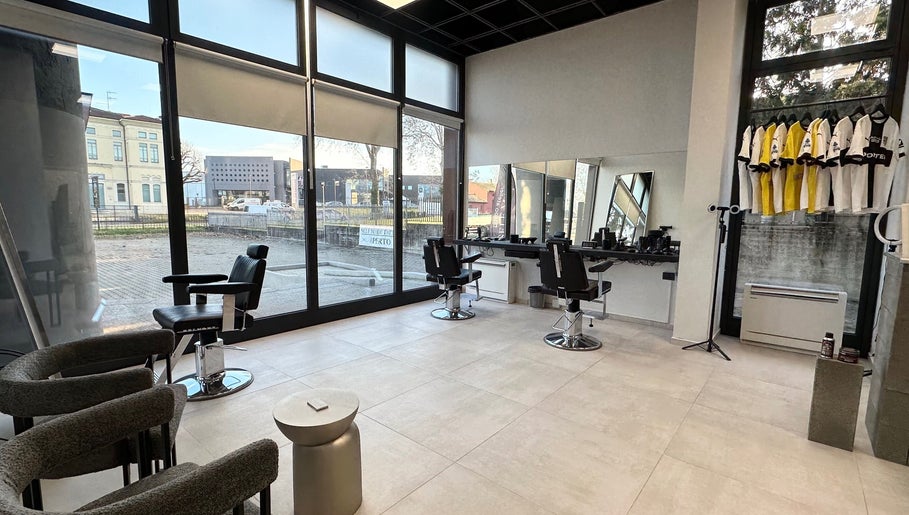 Interno moderno di AVELINO Barbershop CENTRO a Parma, Emilia-romagna, IT con ampie finestre e poltrone da barbiere.