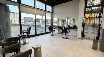 Interno moderno di AVELINO Barbershop CENTRO a Parma, Emilia-romagna, IT con ampie finestre e poltrone da barbiere.