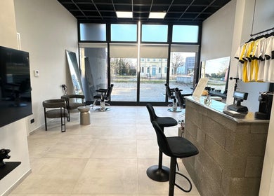 Interno moderno di AVELINO Barbershop CENTRO a Parma, Emilia-romagna, IT con sedie e vetrate ampie.