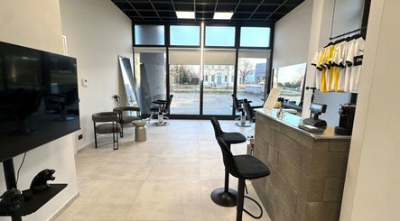 Interno moderno di AVELINO Barbershop CENTRO a Parma, Emilia-romagna, IT con sedie e vetrate ampie.