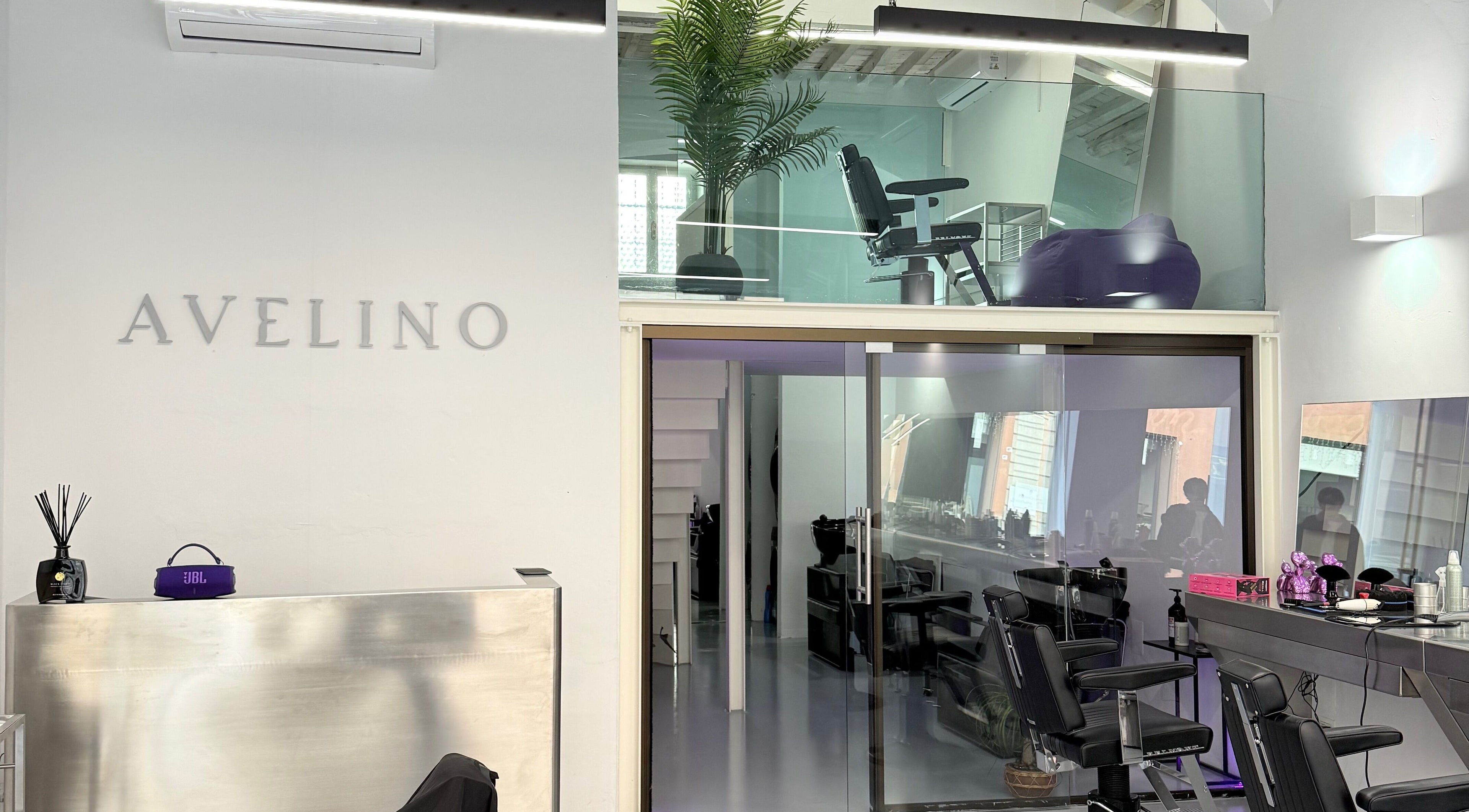Interno moderno di AVELINO Barbershop CENTRO a Parma, Emilia-romagna, IT con sedie e riflessi.