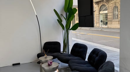 Interno AVELINO Barbershop CENTRO a Parma, Emilia-romagna, IT con poltrone moderne e pianta verde.