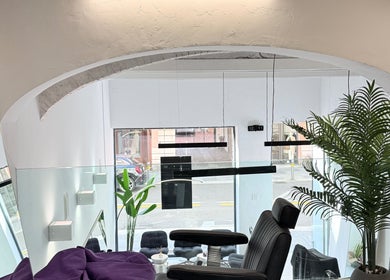 Interno moderno di AVELINO Barbershop CENTRO a Parma, Emilia-romagna, IT con piante e arredi eleganti.