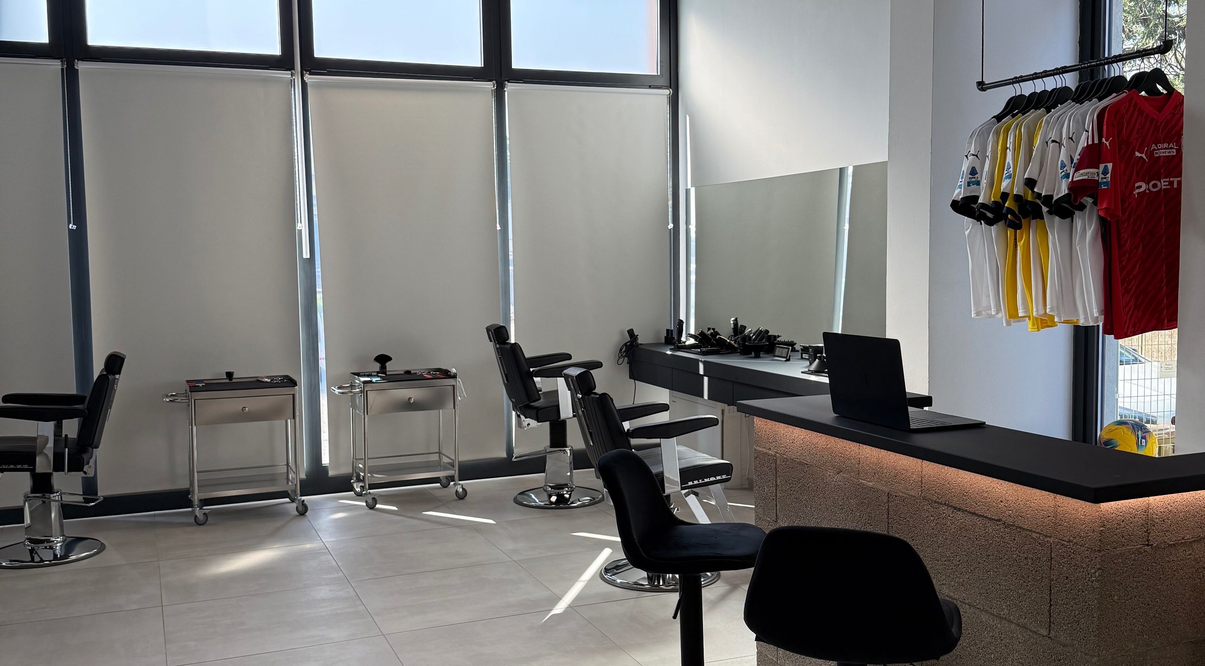 Interno moderno di AVELINO Barbershop LEMIGNANO a Lemignano, Emilia-romagna, IT con sedie e postazioni eleganti.