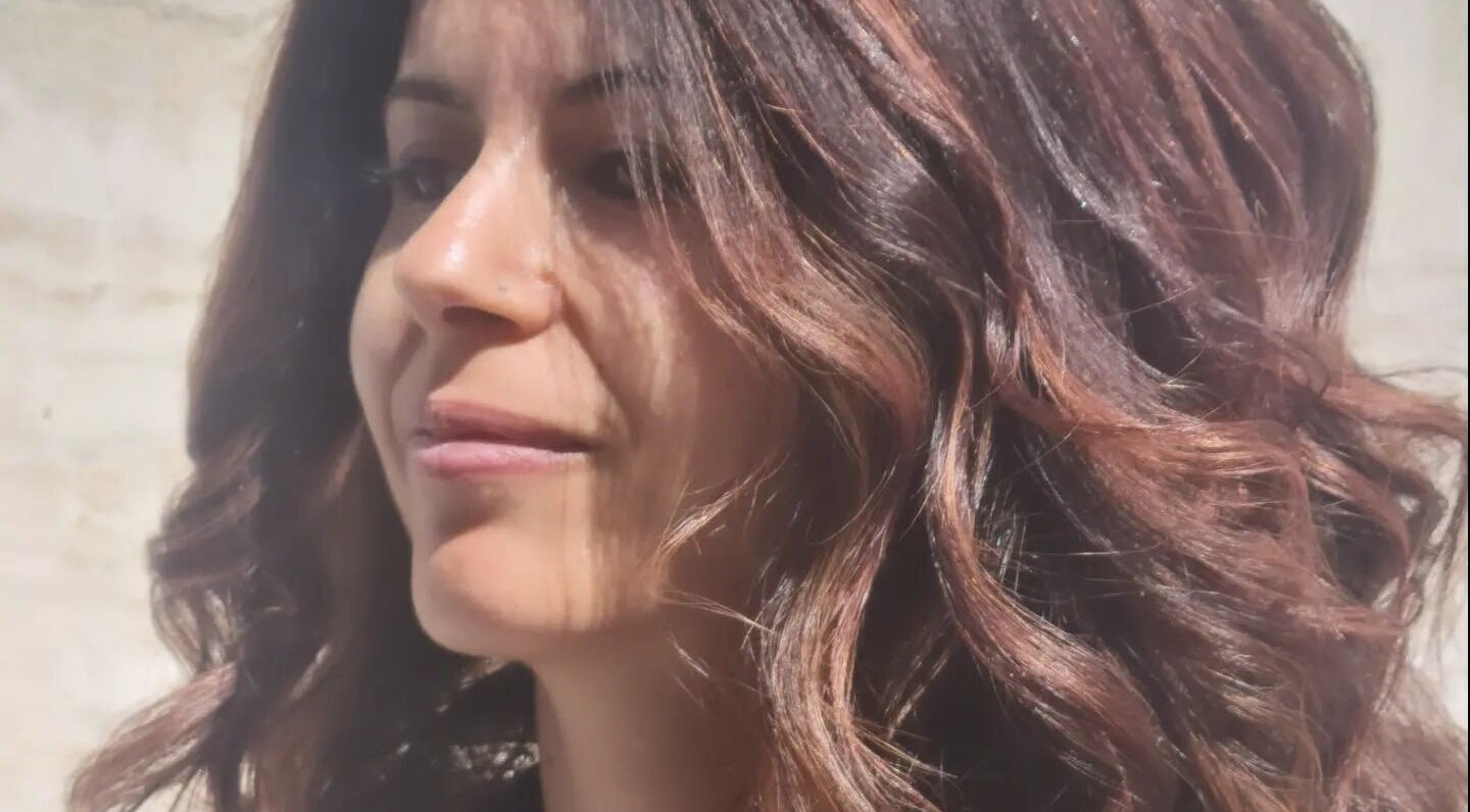 Donna con capelli ondulati e sorriso a Mea Parrucchieri, Torino, Piemonte, IT.