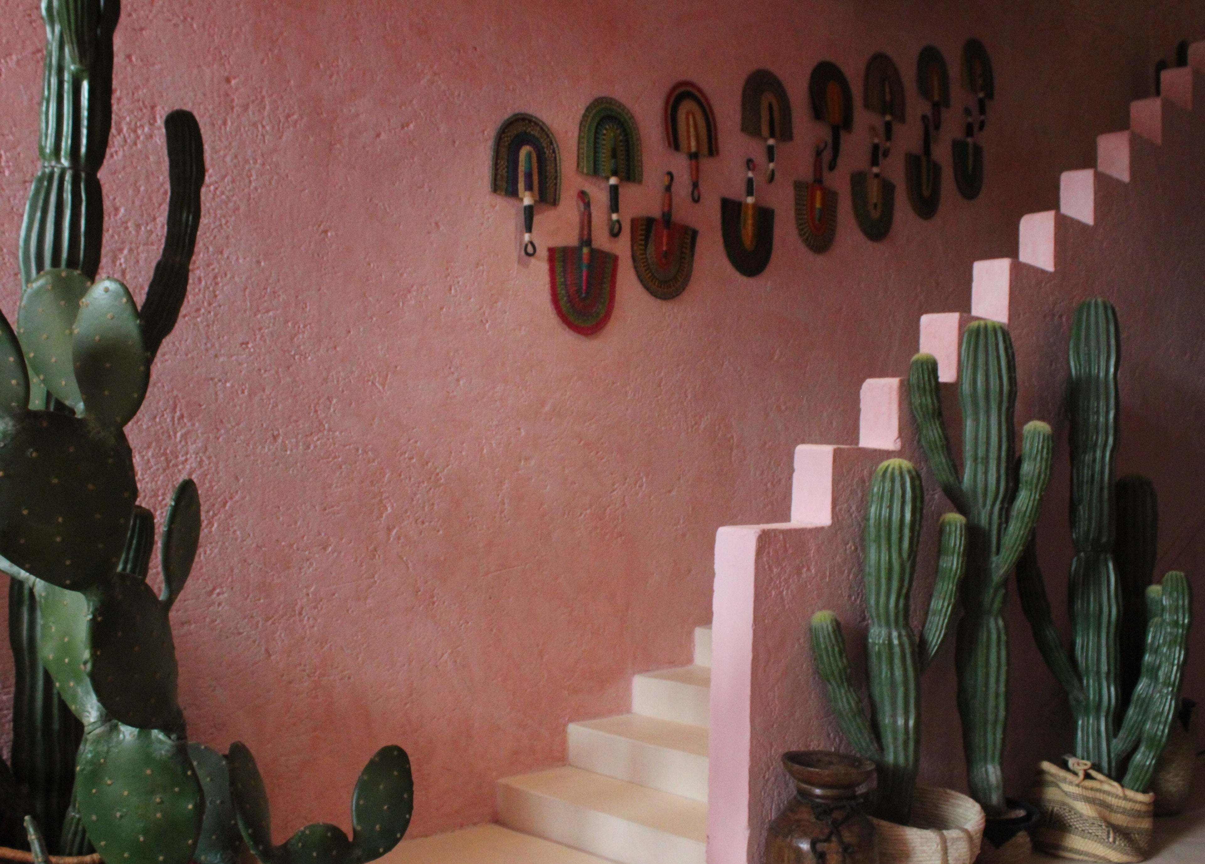 Pinkaboo Nail Boutique in Riyadh features a pink staircase with cacti decor, offering a rustic charm.
