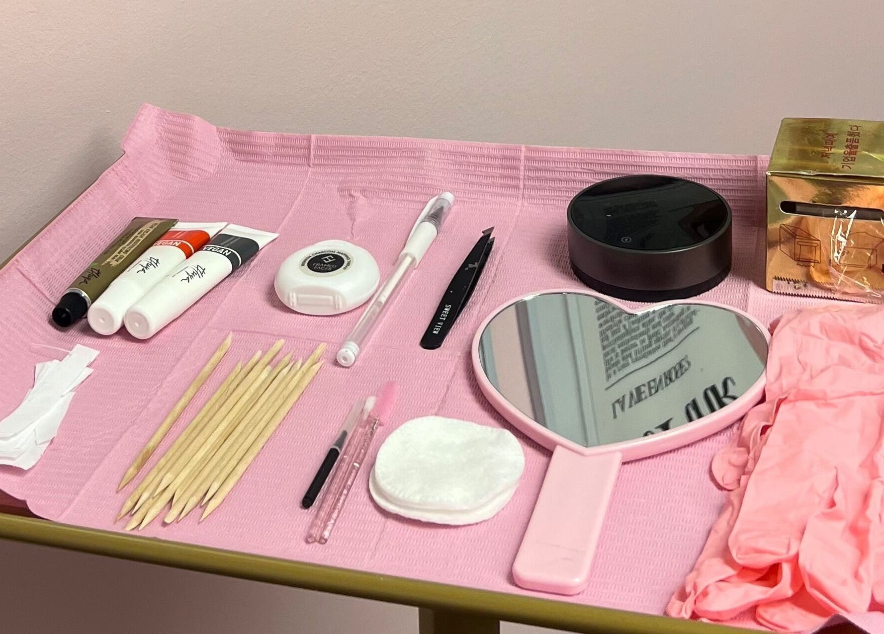 Outils esthétiques sur une table rose à Dollsbytash, Montréal, Québec, CA, pour soins beauté et bien-être.