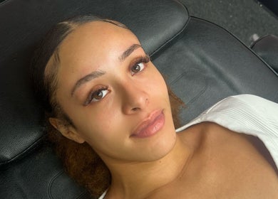 Femme détendue sur fauteuil esthétique chez Dollsbytash, Montréal, Québec, CA, après traitement de beauté.