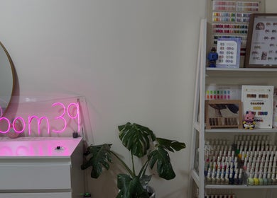 Nails.Room39's chic interior in Green Valley, New South Wales, AU featuring a neon sign and nail color display.