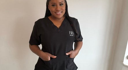 Beauty professional at Bare Bliss Beauty, Thornton Heath, England, GB, wearing branded uniform.