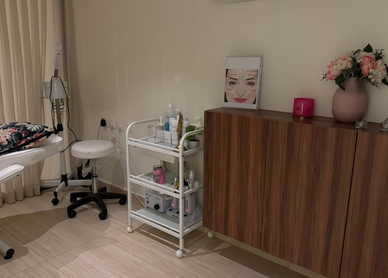 Treatment room at Rosoleen Beauty&Spa صالون روزولين, Riyadh, featuring a floral pillow and skincare essentials.
