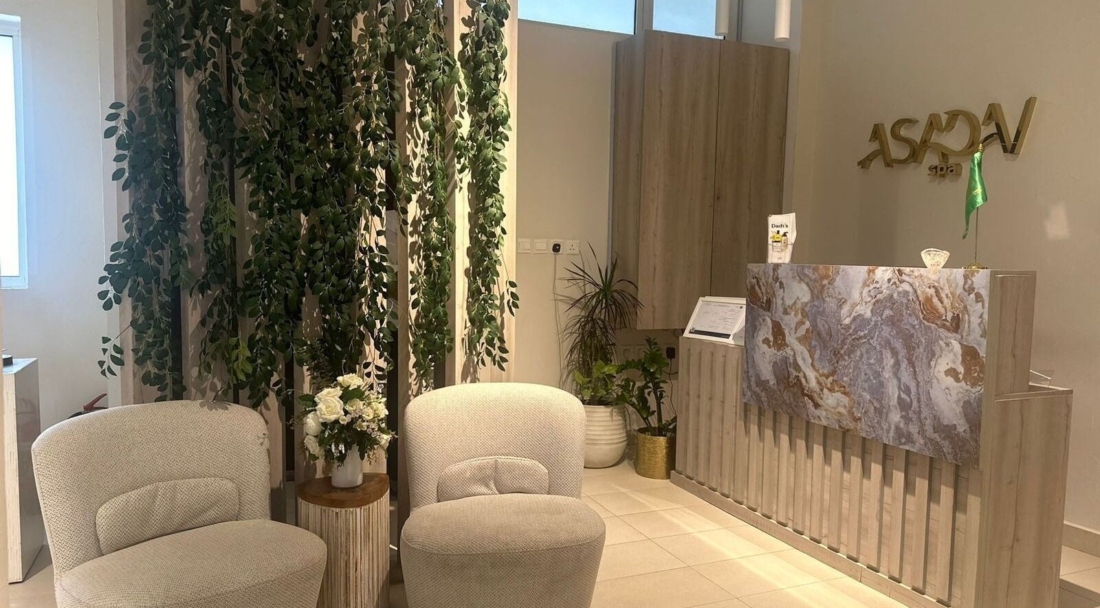 Reception area of أسدان سبا ASADAN spa in Riyadh, Riyadh Province, SA with modern decor and greenery.