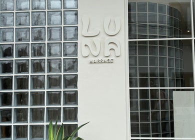 Front view of Luna Massage Seseh entrance in Bali, Bali, ID with glass block wall and logo.