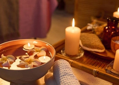 Candles and flowers create a serene setting at Vedhavillage Spa Trivandrum, Kulathoor, Kerala, IN.