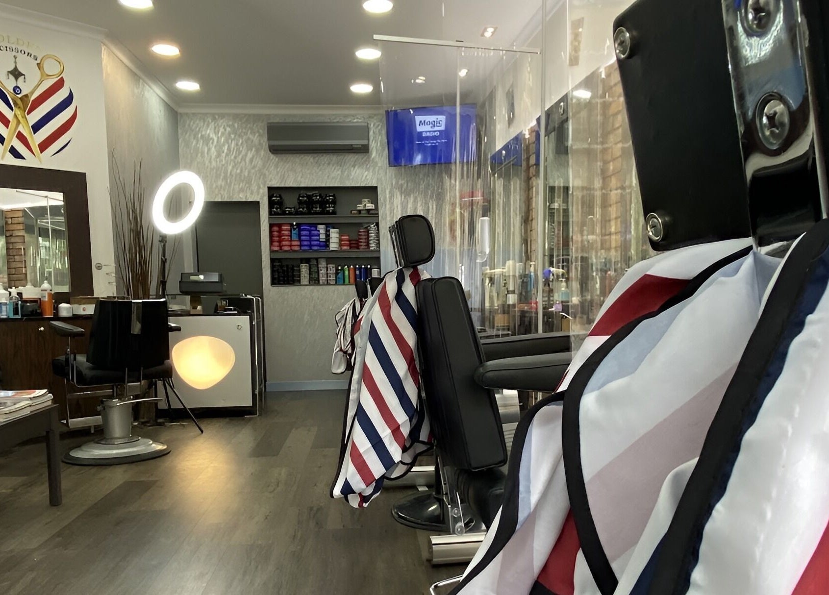 Modern interior of GOLDEN SCISSORS barber shop in London, England, GB with stylish chairs and decor.