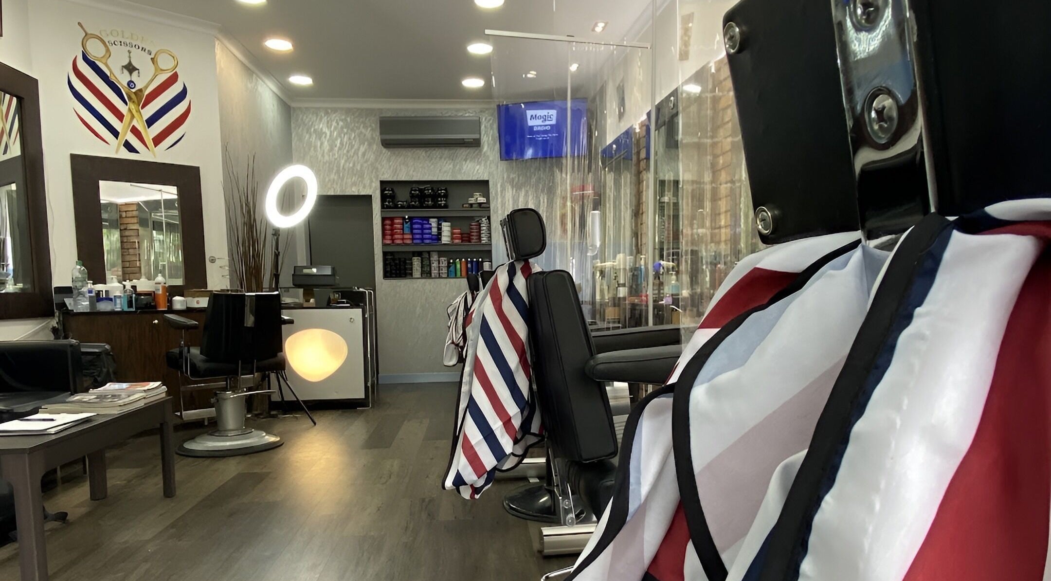 Modern interior of GOLDEN SCISSORS barber shop in London, England, GB with stylish chairs and decor.