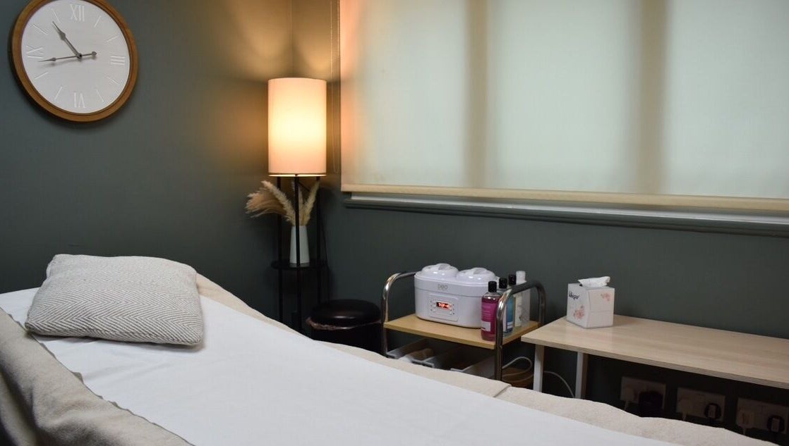 Cozy treatment room at Elite Intimate Waxing in Ruddington, England, GB with bed, warm lighting, and waxing equipment.
