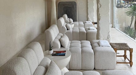 Cozy seating at Aetheria Natural Healing Spa in Canggu, Bali, ID, featuring plush white sofas and calming decor.