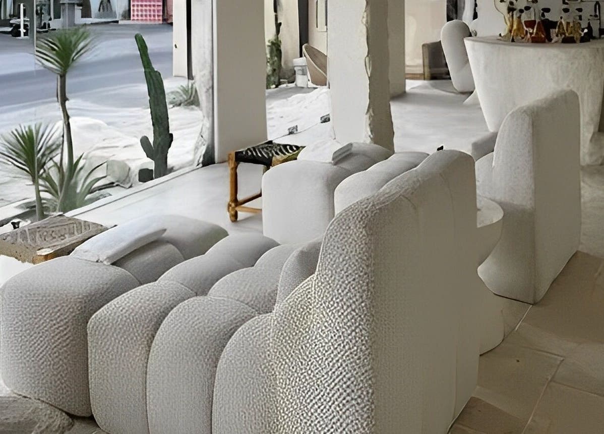 Luxurious interior of Aetheria Natural Healing Spa in Canggu, Bali, with white seating and greenery.