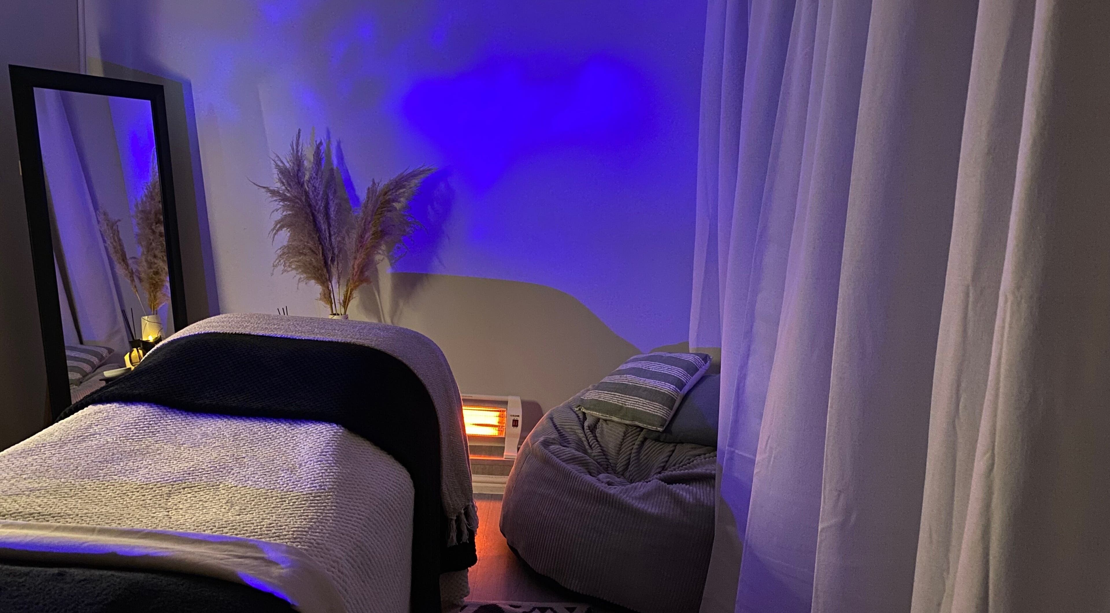 Relaxing spa room at Fond Of Skin, Cape Town, Western Cape, ZA with blue lighting and cozy decor.