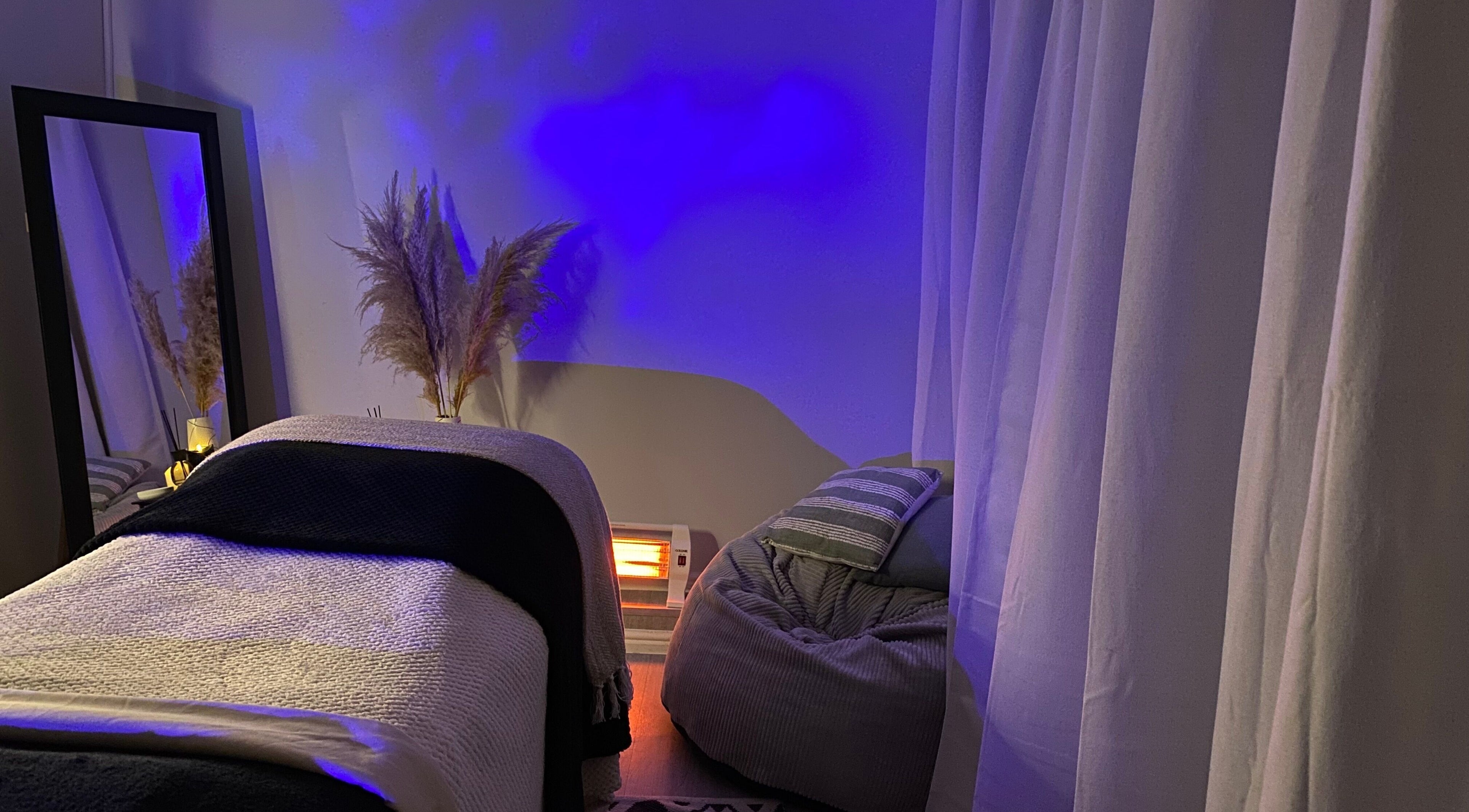 Relaxing spa room at Fond Of Skin, Cape Town, Western Cape, ZA with blue lighting and cozy decor.