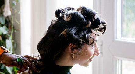 Woman getting her hair styled in elegant curls at Zulu Bonita, London, England, GB.