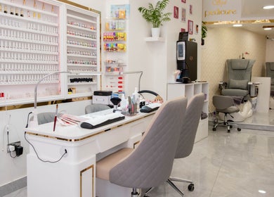 Elegant manicure setup at Kingscross Nails, London, England, GB with seating and nail polish display.