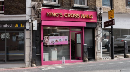 Exterior of Kingscross Nails salon in London, England, GB with a vibrant pink storefront.
