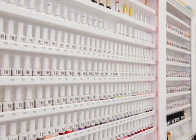 Extensive nail polish collection display at Kingscross Nails, London, England, GB, offering diverse color choices.