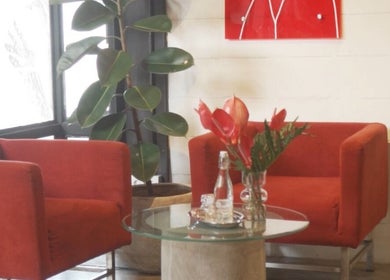Inviting lounge area at Sculptura: Anti-Cellulite & Body Sculpting, Bali, Bali, ID with red chairs and glass table.