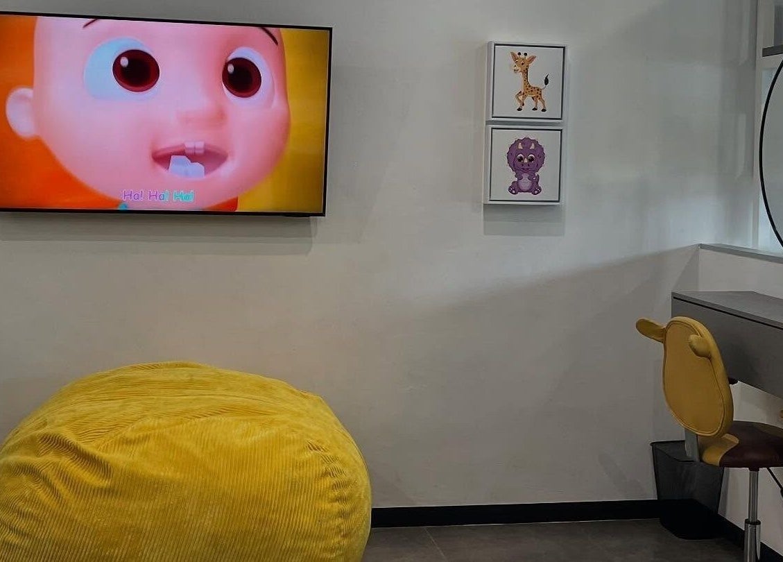 Bright children's area at Tots And Teens, Sandton, Gauteng, ZA, featuring a TV and decorative seating.