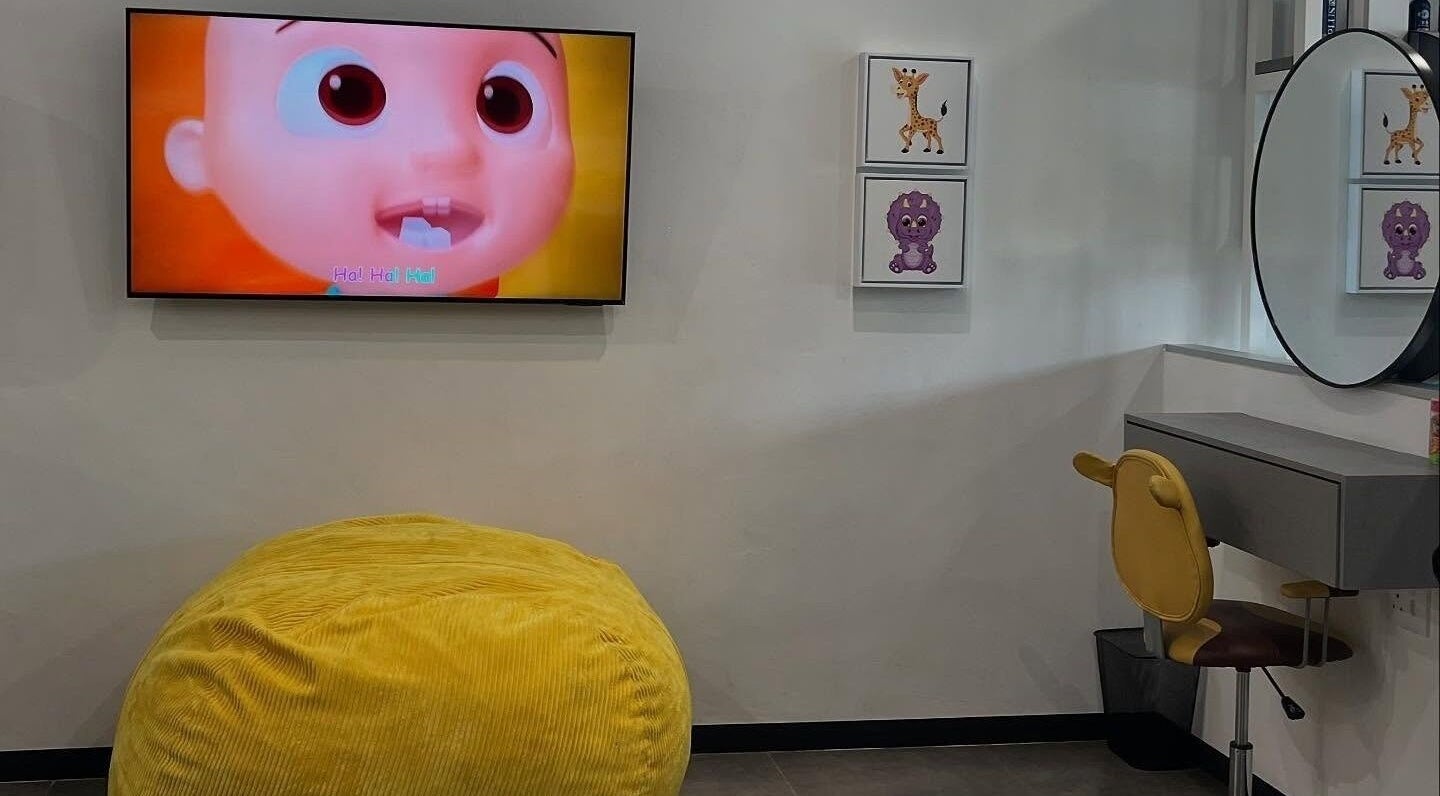 Bright children's area at Tots And Teens, Sandton, Gauteng, ZA, featuring a TV and decorative seating.