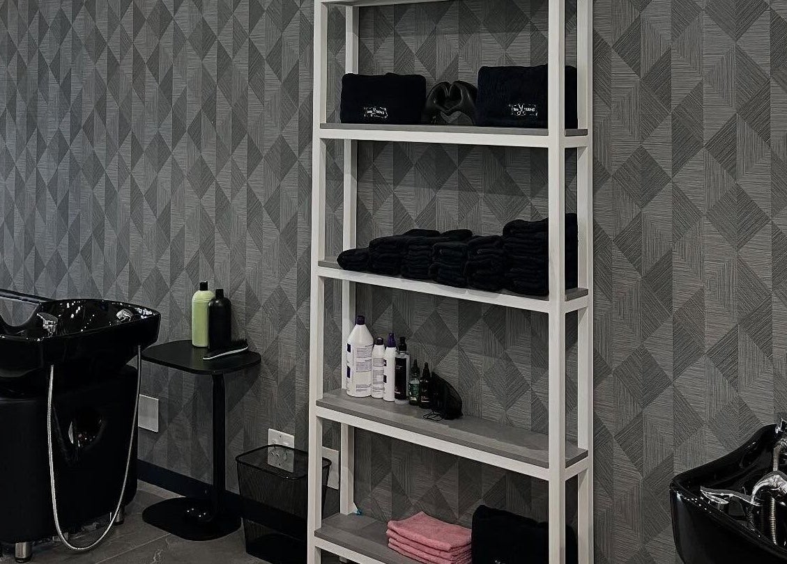 Modern hair washing station at Tots And Teens, Sandton, Gauteng, ZA with sleek black sinks and organized shelves.