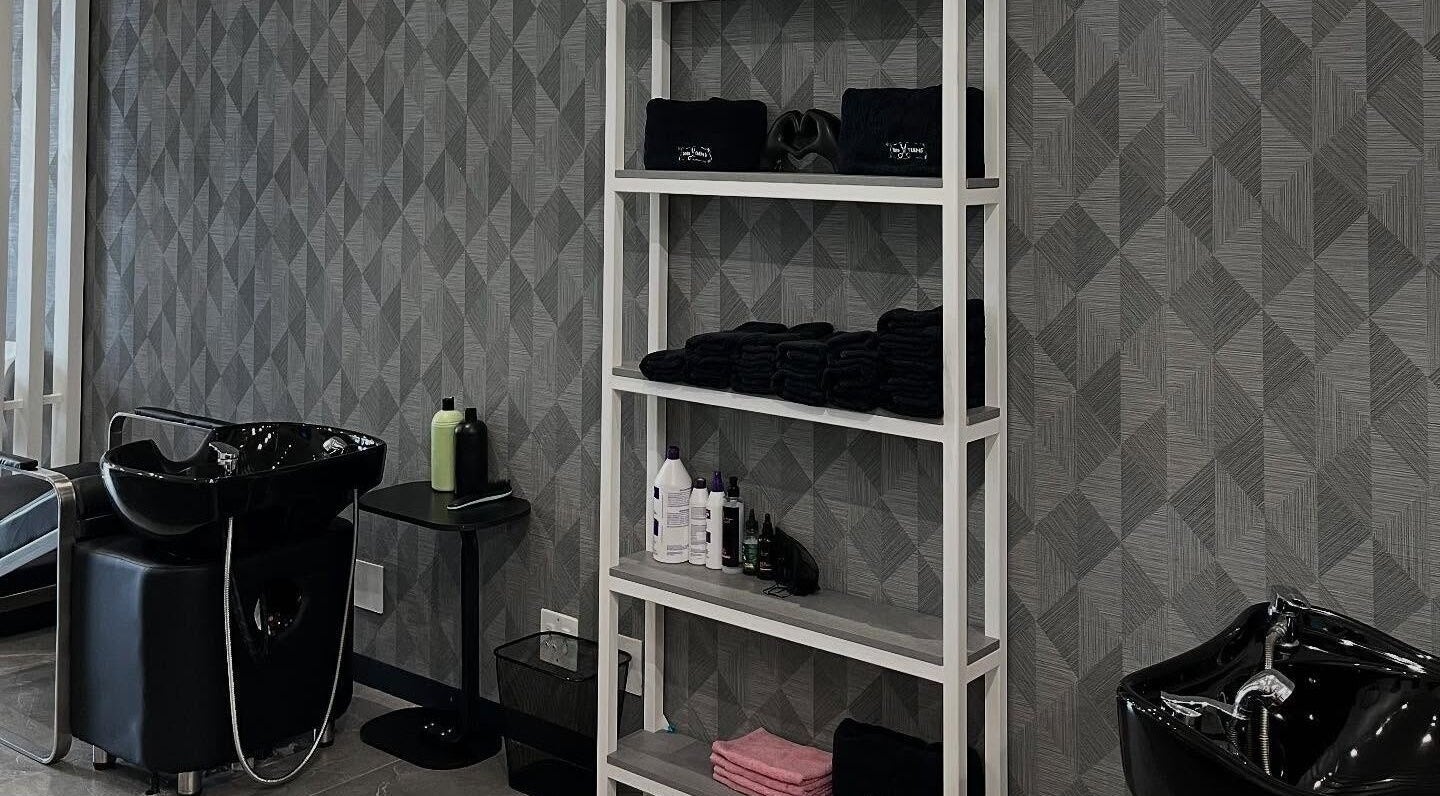 Modern hair washing station at Tots And Teens, Sandton, Gauteng, ZA with sleek black sinks and organized shelves.