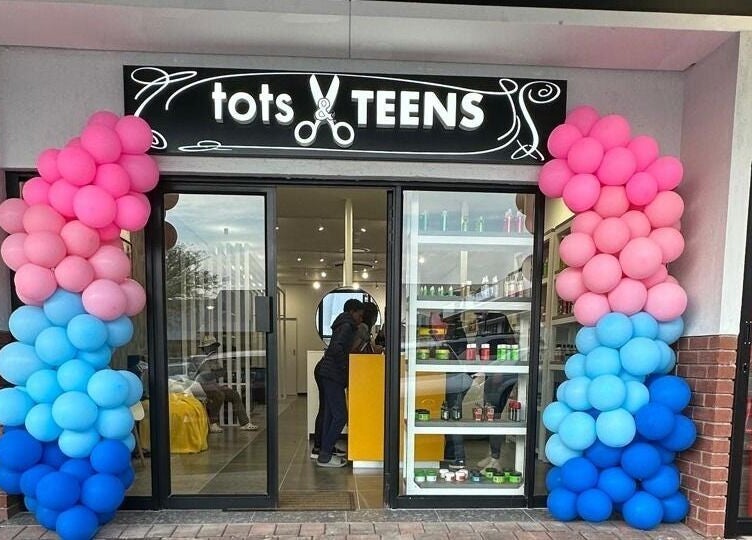 Entrance of Tots And Teens in Sandton, Gauteng, ZA with vibrant pink and blue balloon decorations.