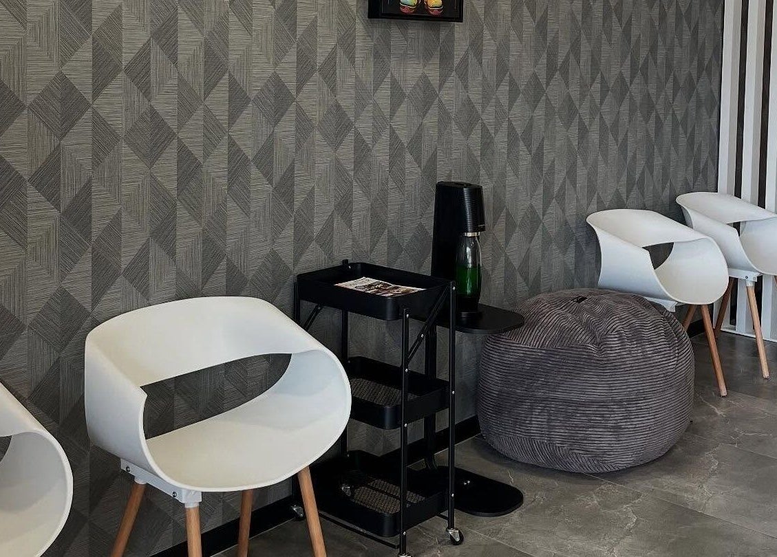 Modern seating area at Tots And Teens, Sandton, Gauteng, ZA with stylish white chairs and geometric walls.