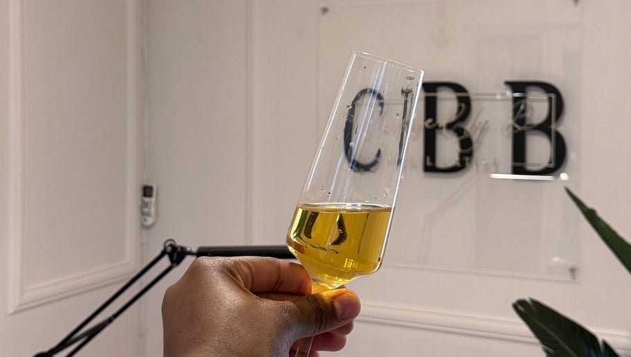 Champagne glass at Clawed by B (Pty) Ltd, Rustenburg, North West, ZA with logo in background.