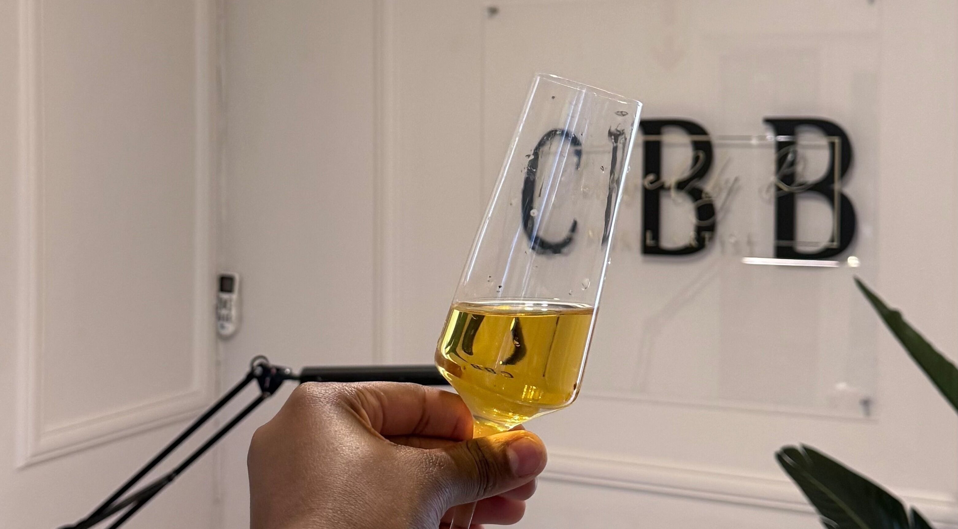 Champagne glass at Clawed by B (Pty) Ltd, Rustenburg, North West, ZA with logo in background.