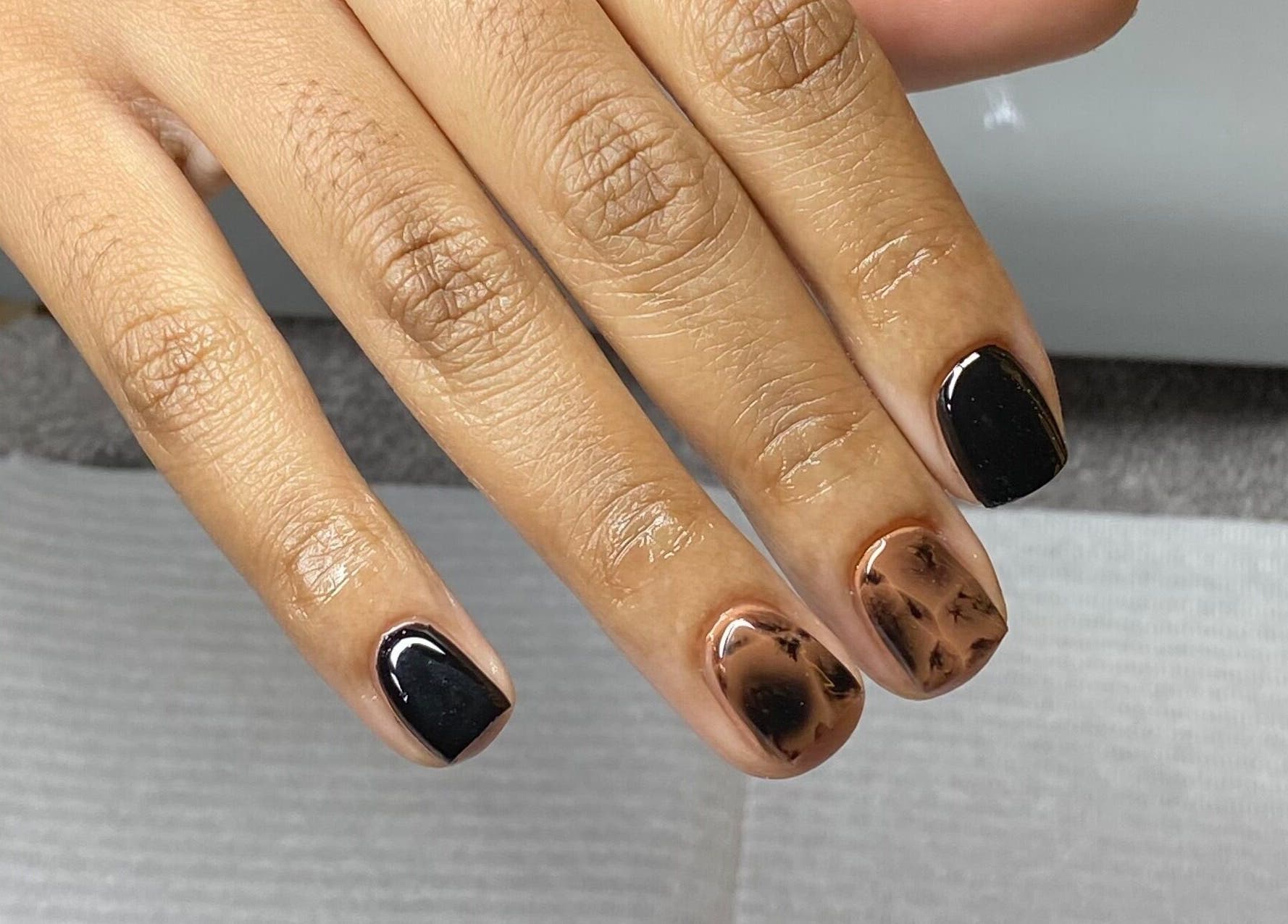 Stylish marble and black manicure by Clawed by B (Pty) Ltd in Rustenburg, North West, ZA.