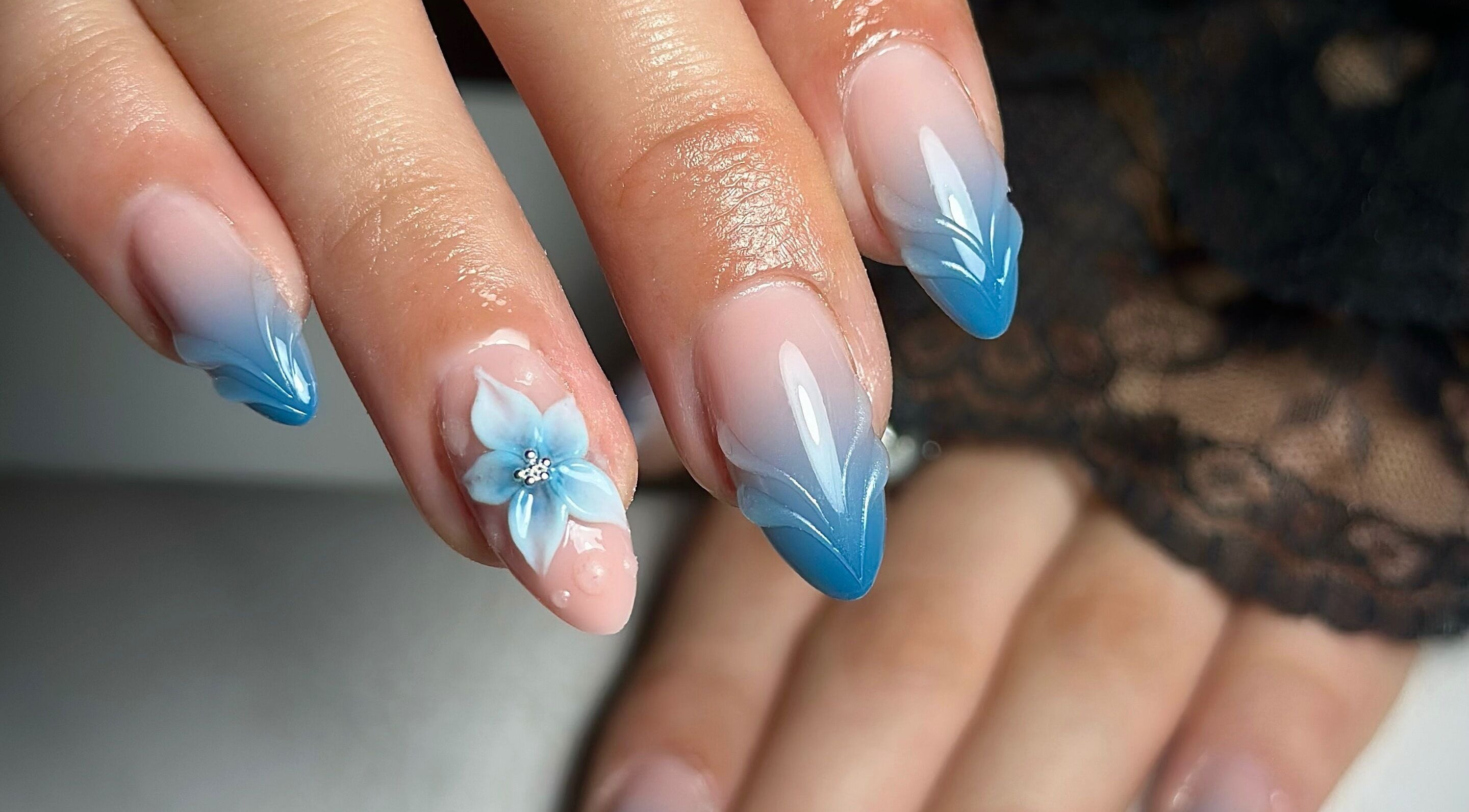Elegant blue gradient nail art with floral design from Nailsby.Jona in Coventry, England, GB.