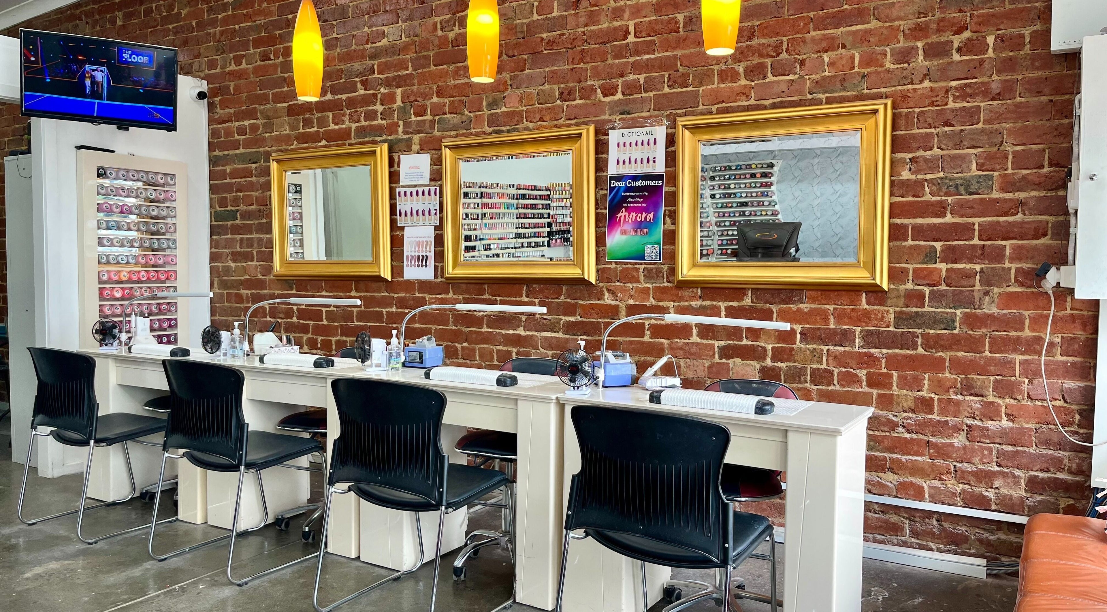 Modern nail stations at Aurora Nails and Beauty | Watsonia in Melbourne, Victoria, AU with warm lighting and brick wall.