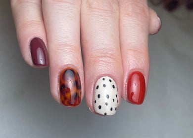 Stylish nail art featuring maroon, tortoiseshell, and polka dots at Jordon at Amica Hair & Beauty, Thirsk, England, GB.
