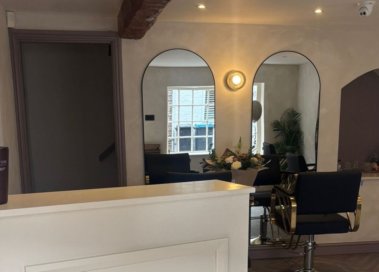 Chic salon interior at Jordon at Amica Hair & Beauty in Thirsk, England, GB, featuring elegant black chairs and a mirror.