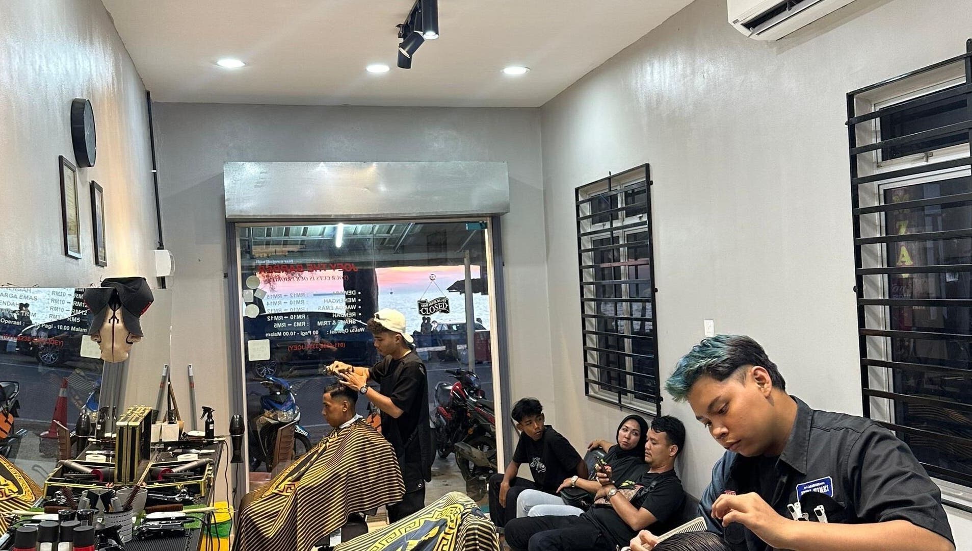Stylish salon scene at TRYM, Tanjung Kling, Malacca, MY, featuring clients and hairstylists in a modern setting.