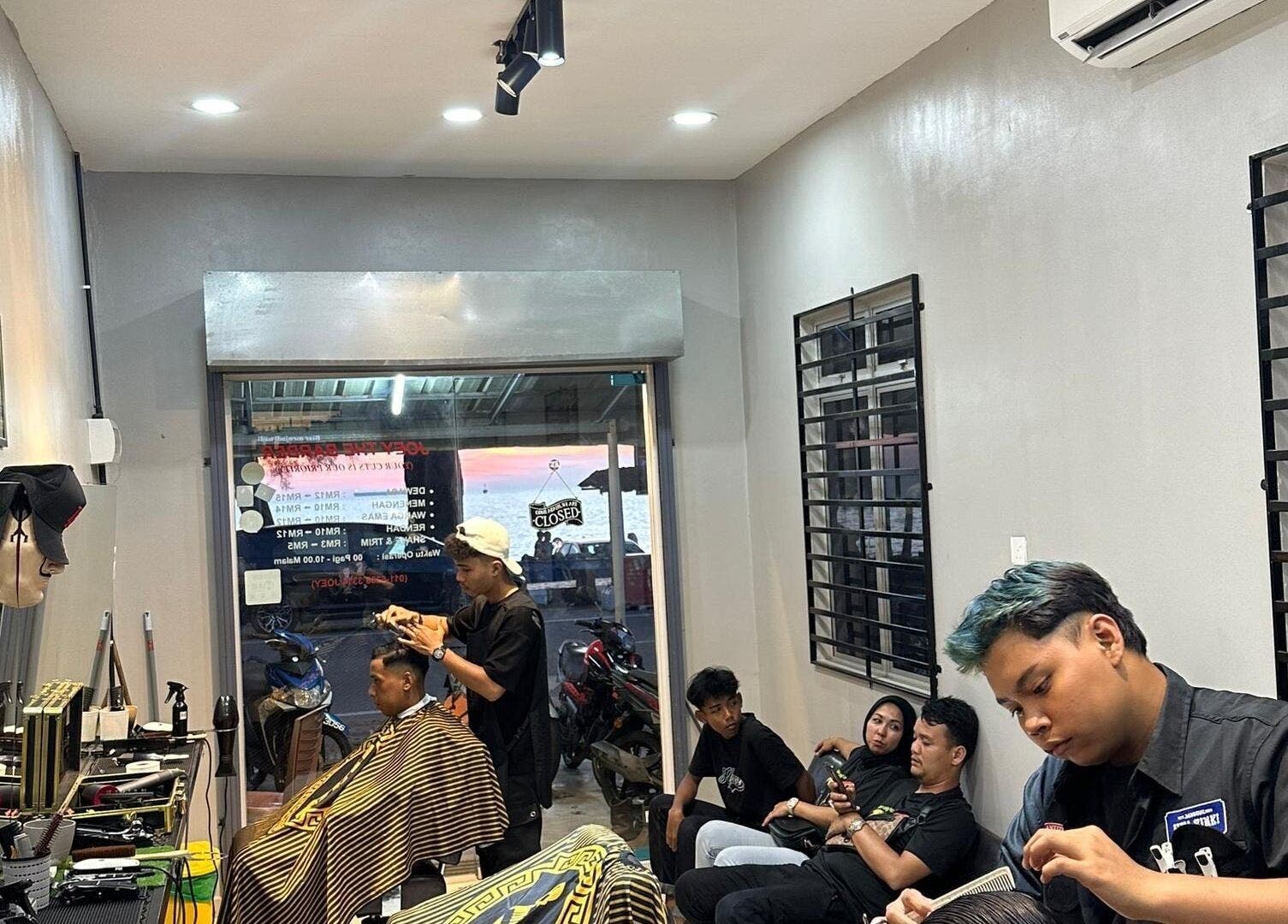 Stylish salon scene at TRYM, Tanjung Kling, Malacca, MY, featuring clients and hairstylists in a modern setting.