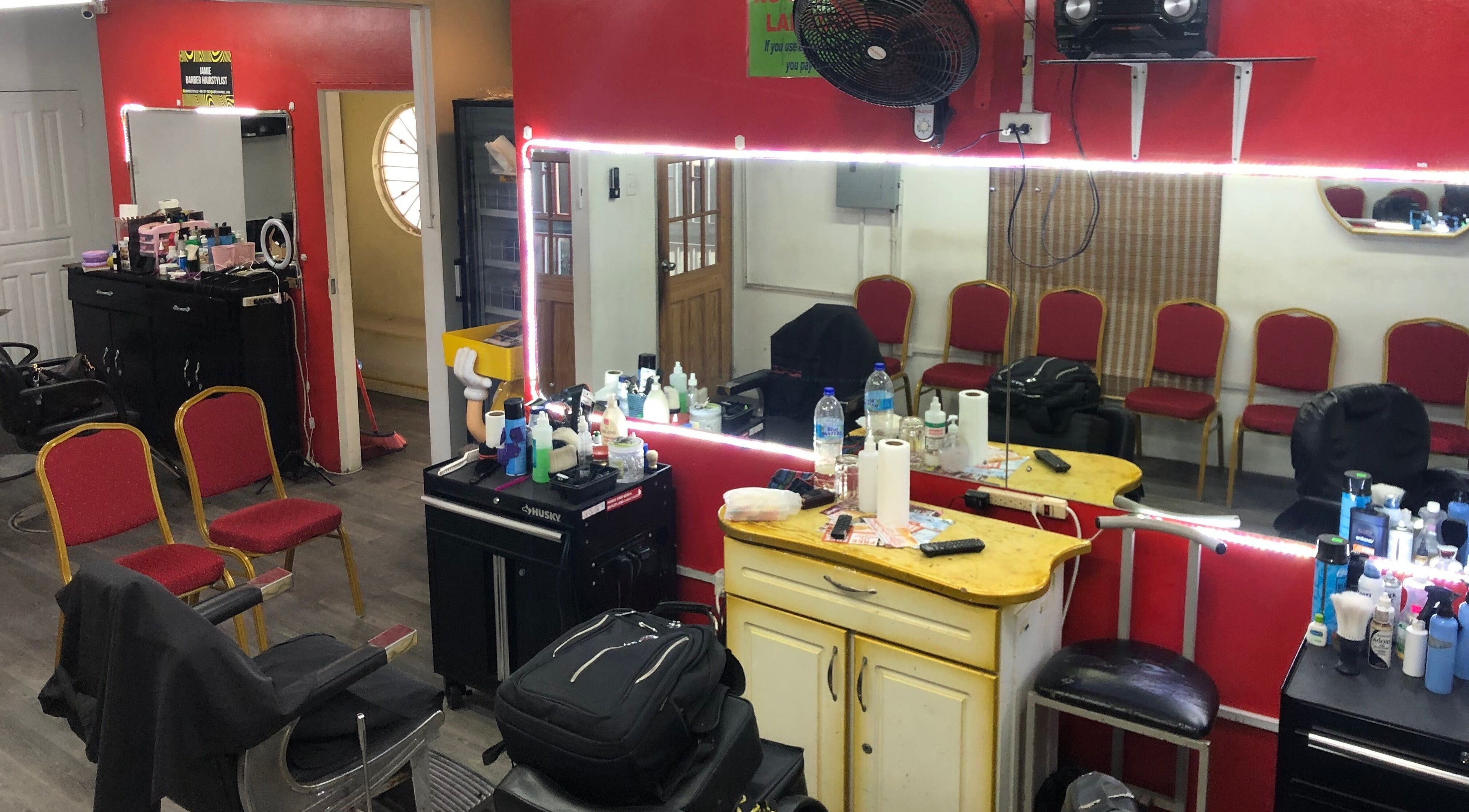 Interior of Legitimate Finishes Barber Shop in Port of Spain, showcasing styling stations and chairs.