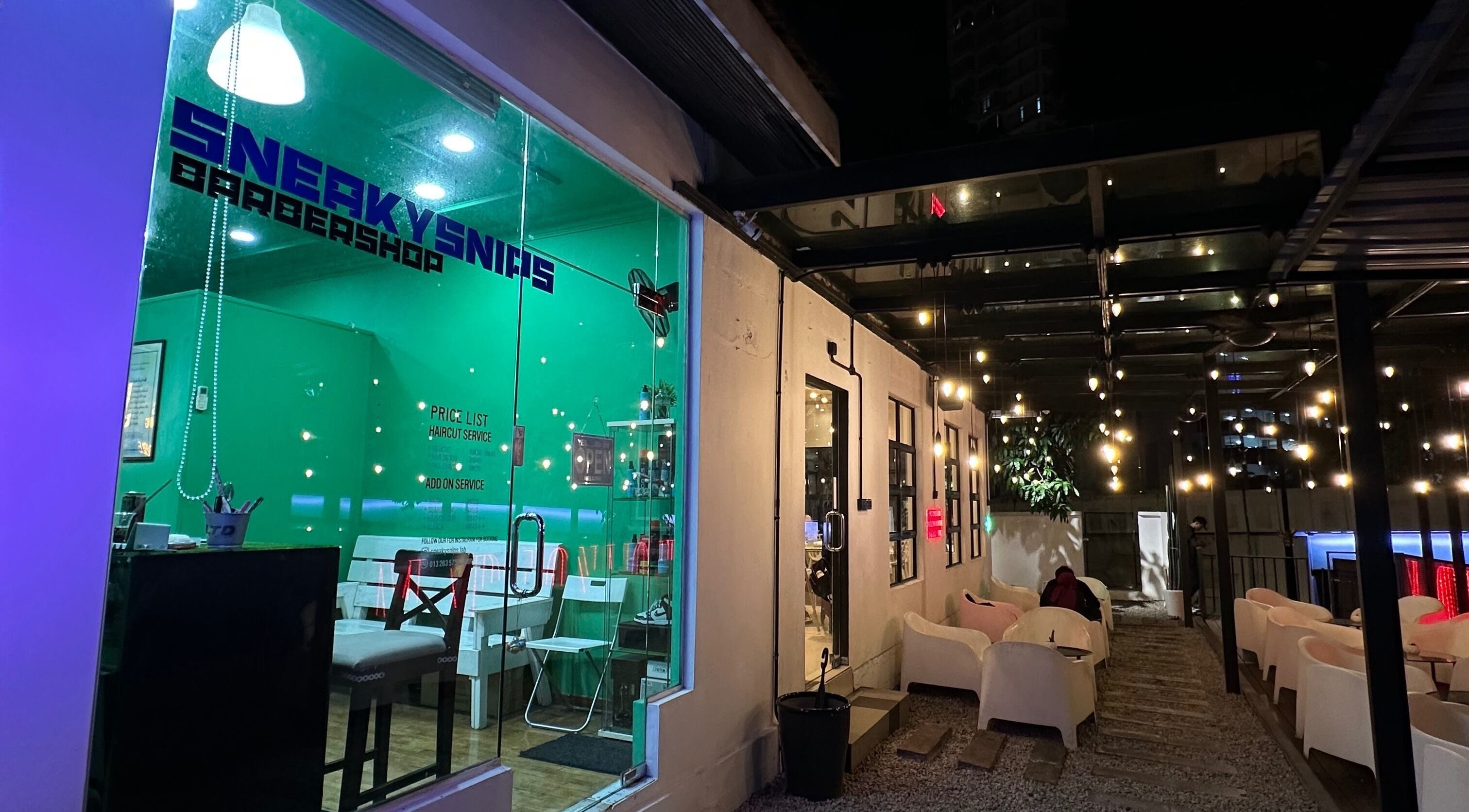 SNEAKYSNIPS BARBERSHOP entrance with seating area in Johor Bahru, Johor Darul Ta'zim, MY under stylish lighting.