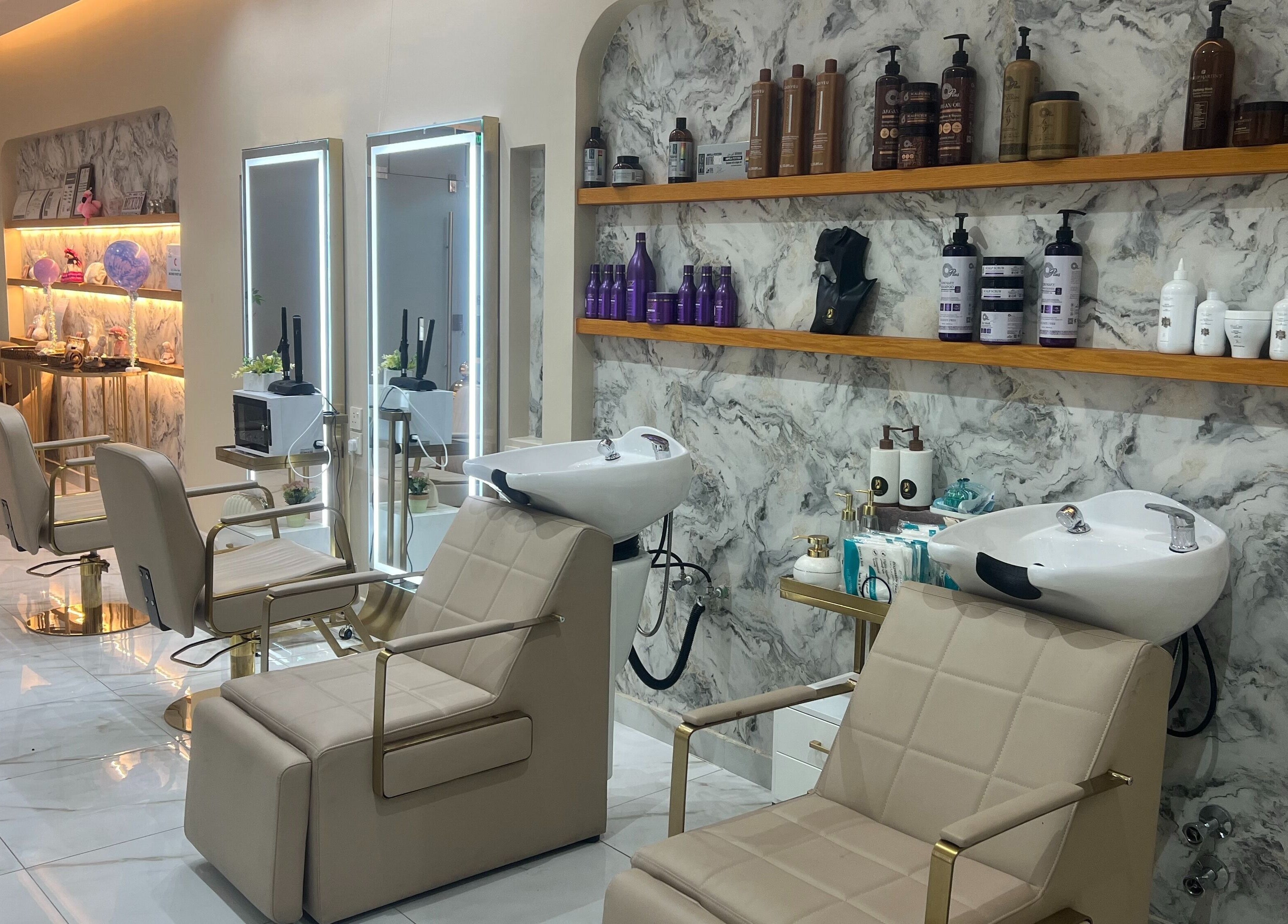 Elegant interior of Wejdan Aljamal Beauty Salon in Dhahran, SA with chic styling chairs and a marble backdrop.